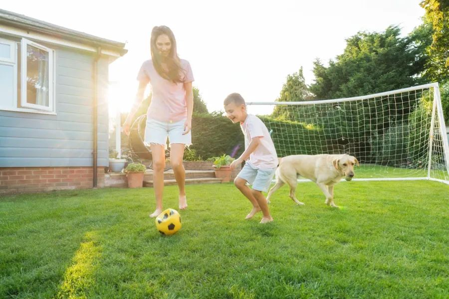 family-playing-soccer-on-lawn